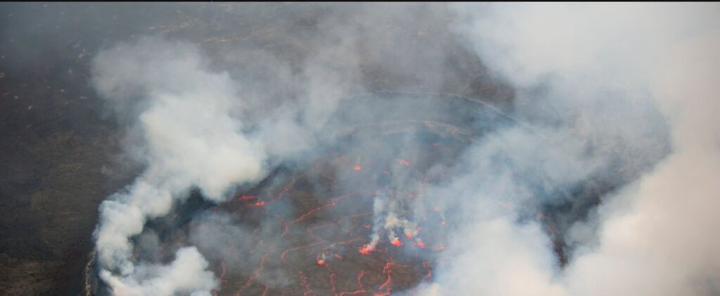 Hikers standing at the summit of Mount Nyiragongo overlooking the glowing lava lake during a 3 Days hike.