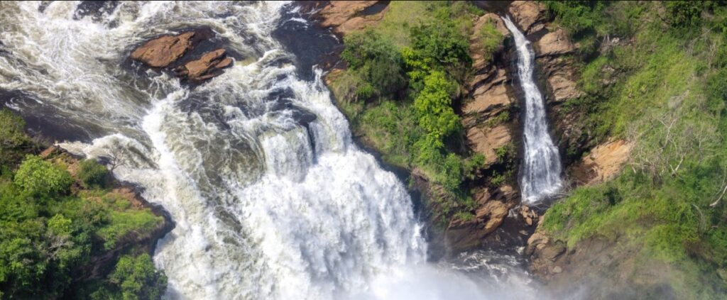 Tourists on 2 Days Murchison Falls Safari enjoying game drive, Nile cruise, and powerful waterfall views.